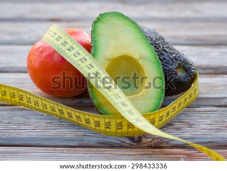 Fresh vegetables with a tape measure on a wooden background