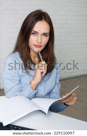 Girl secretary wondered when completing documents and held a pen to her chin