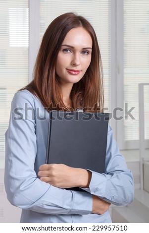 Girl in formal attire holding a folder for documents
