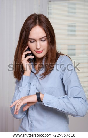 Girl in formal dress talking on the phone and looking at her watch