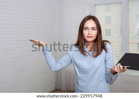 Woman in formal attire holding a folder expressing bewilderment