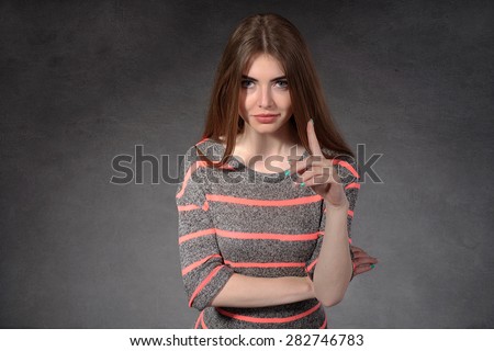 Concept human emotions. Young girl showing distrust against the dark background