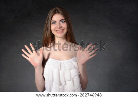 Concept human emotions. Girl showing surprise against a dark background