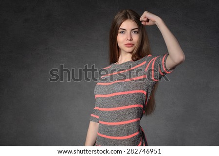 Concept human emotions. Woman demonstrates that she is strong against the dark background