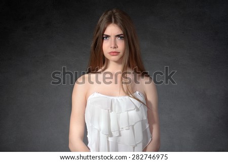 Concept human emotions. Woman shows a grudge against a dark background