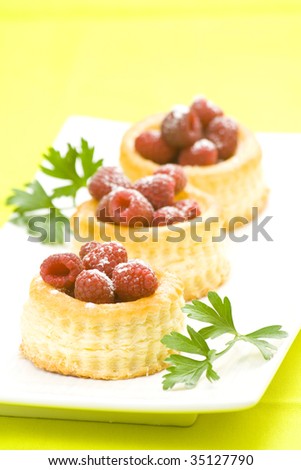 raspberry pastry cream and decorated with lemon parsley isolated