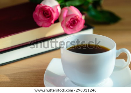Books, coffee and roses on wooden table