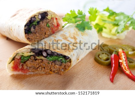 Beef Burrito On Wooden Board With Red Chillies Peppers