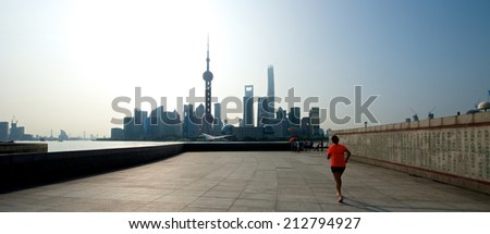 Shanghai, China - August 6, 2014: A beautiful view of Shanghai Skyline at sunrise with people running.