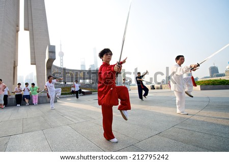 Shanghai, China - August 6, 2014: A beautiful view of Shanghai Skyline at sunrise with people doing Tai Chi.