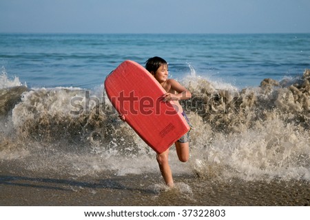 Boy running with surfing board