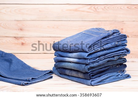 Piles of jeans on wooden background