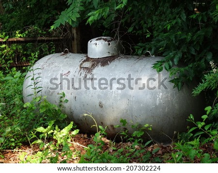 Vintage rusting silver-colored large residential liquid propane tank