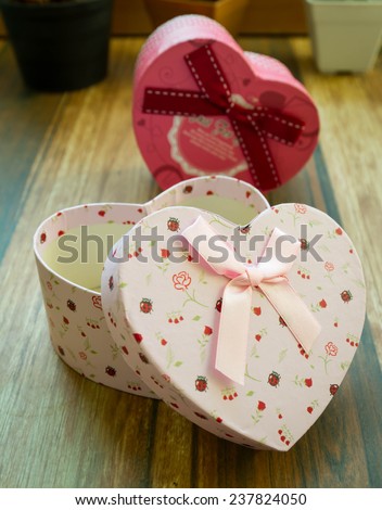 Heart shaped Valentines Day gift box on old wood. Vintage holiday background.