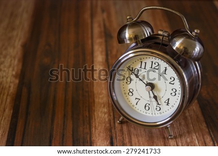 Old fashioned alarm clock on wood table  background
