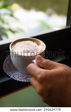 A cup of coffee in hand.