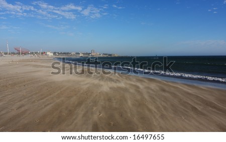 Strong wind drives waves of sand over deserted beach, Porto Portugal