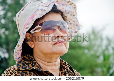 an older people wear pink hat and look ahead