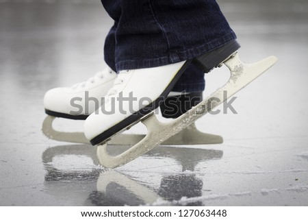 A female ice skaters skates on a frozen pond in northern Maine