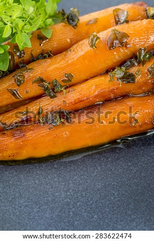 Selective Focus on Roasted baby carrots with fresh herbs and olive oil room for text and copy space