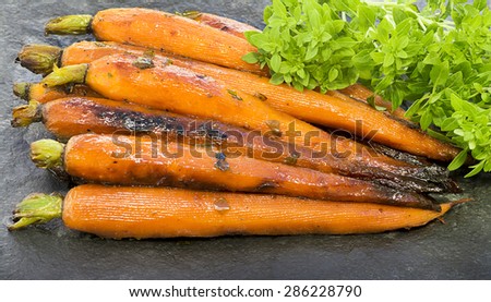 Fresh new Carrots, Roasted in olive oil with herbs and laid out on a slate slab with garnish