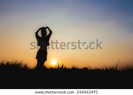 silhouette of woman at sunset , Standing posture , near Dim atmosphere