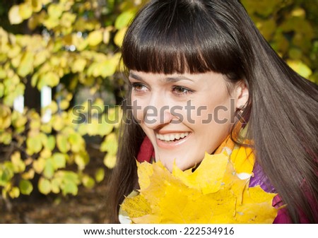 girl with the maple leaves in the autumn park