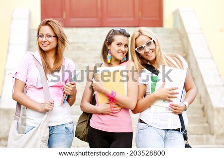 happy young high school students or college girls standing in front of the school and is looking forward to the finished school classes/happy young high school students