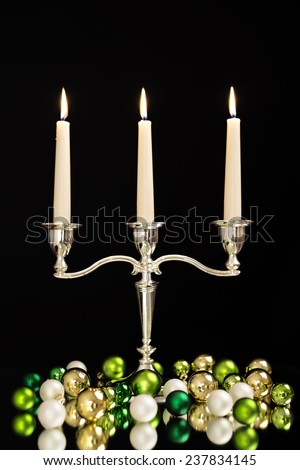 candlestick with three candles, green, gold and pearl Christmas tree balls as Christmas and New Year decoration/Christmas decoration