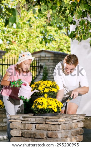 Mom and daughter planting flowers in pots/Mom and daughter planting flowers in pots