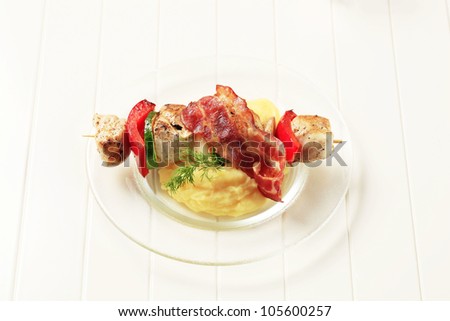 Chicken shish kebab with mashed potato and rasher of bacon