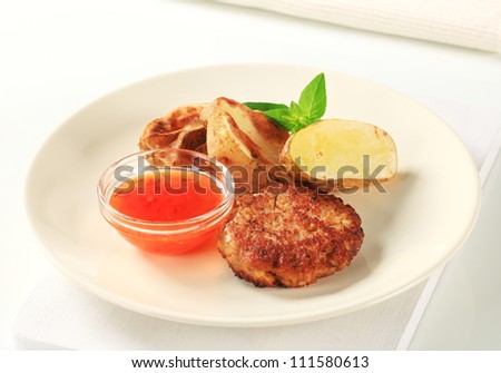 Vegetable patty with roasted potatoes and spicy dip