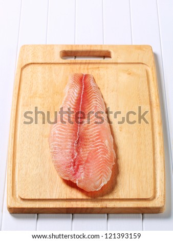 Frozen fish fillet on a cutting board