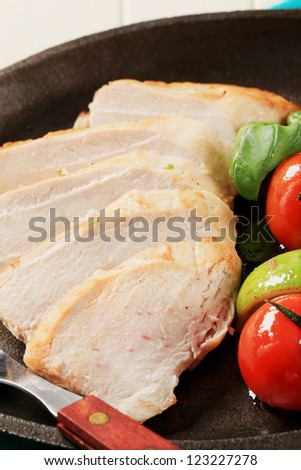 Sliced chicken breast on a skillet