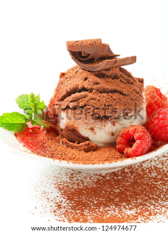Vanilla chocolate ice cream and raspberries sprinkled with cocoa powder