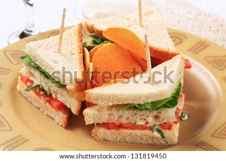 three  small sandwiches with potato crisps