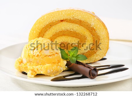 sponge cake roulade with scoops of ice cream and chocolate curl
