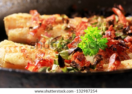 detail of codfish fillet fried in a pan