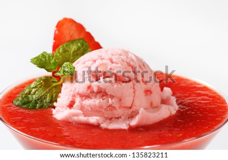 detail of ice cream scoop immersed in a strawberry sorbet