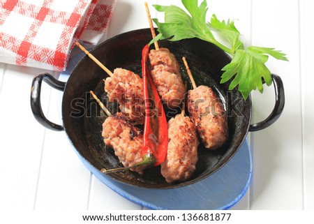 Spicy meat skewer in a pan above view