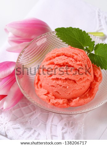 strawberry ice cream in a glass bowl decorated with fresh tulip blossoms