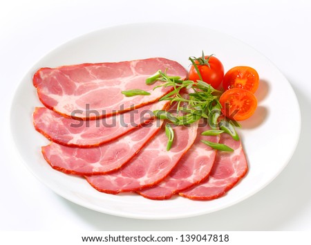 plate of shaved pork neck with spring onion and cherry tomatoes