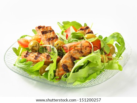 Plate of salad with grilled burger,tomatoes and olives