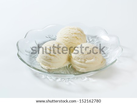 portion of pure white ice cream scoops on a glass plate