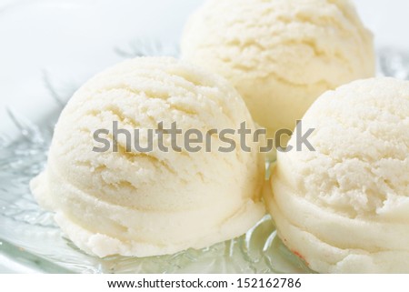 pure white ice cream scoops on a glass plate