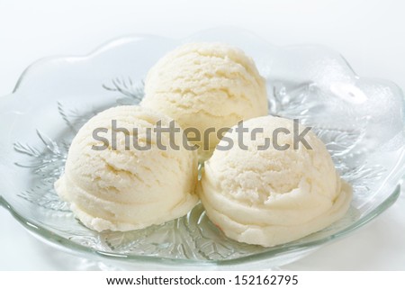 three pure white ice cream scoops on a glass plate