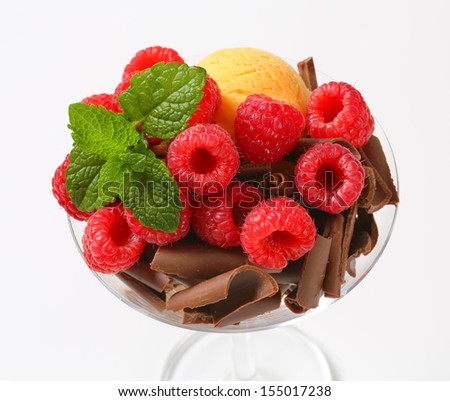 delicious ice cream sundae with raspberries and chocolate curls