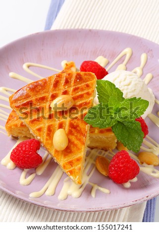 overhead view of dessert with ice cream, almond sponge cake and fresh raspberries