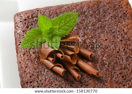 detail of chocolate cake decorated with chocolate curls and mint