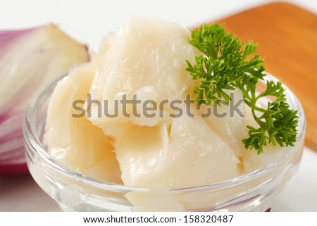 detail of lard in a glass bowl with onion and cutting board on a background